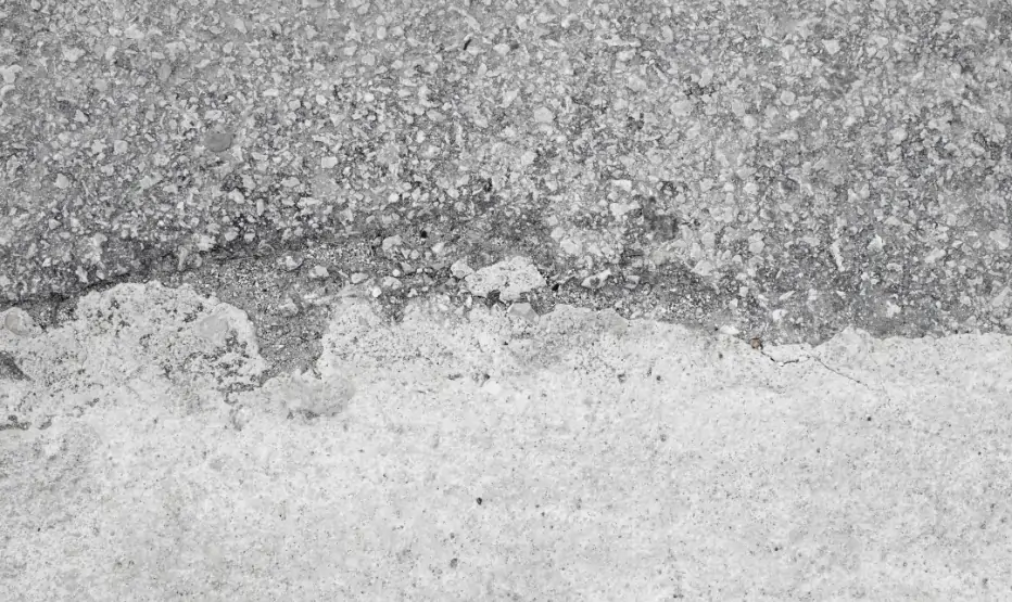 Salt damage to concrete surface showing white salt deposits and surface deterioration caused by moisture penetration.